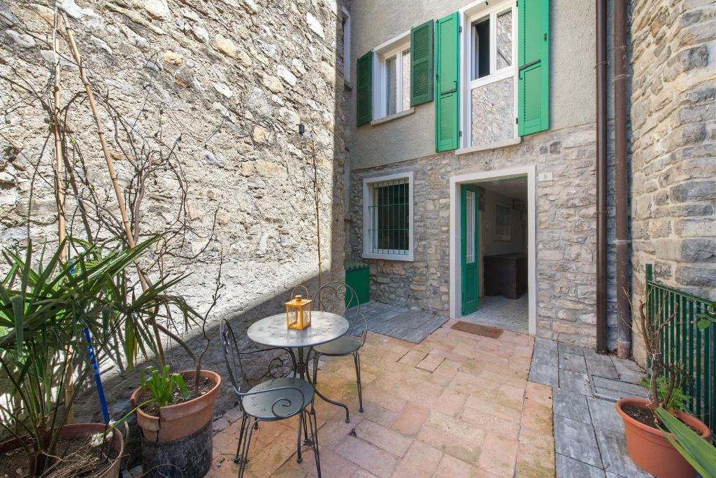 a patio with a table in front of a building at Prima Del Cielo -Appartamento Monti in Esino Lario