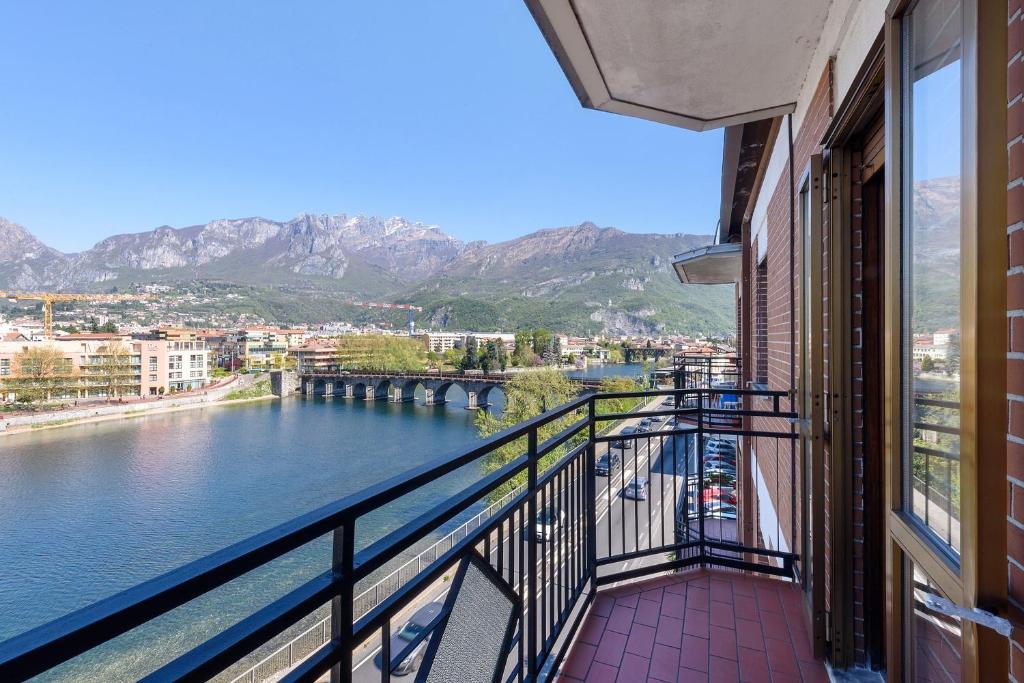 a balcony with a view of a river and mountains at La terrazza sull’Adda in Malgrate