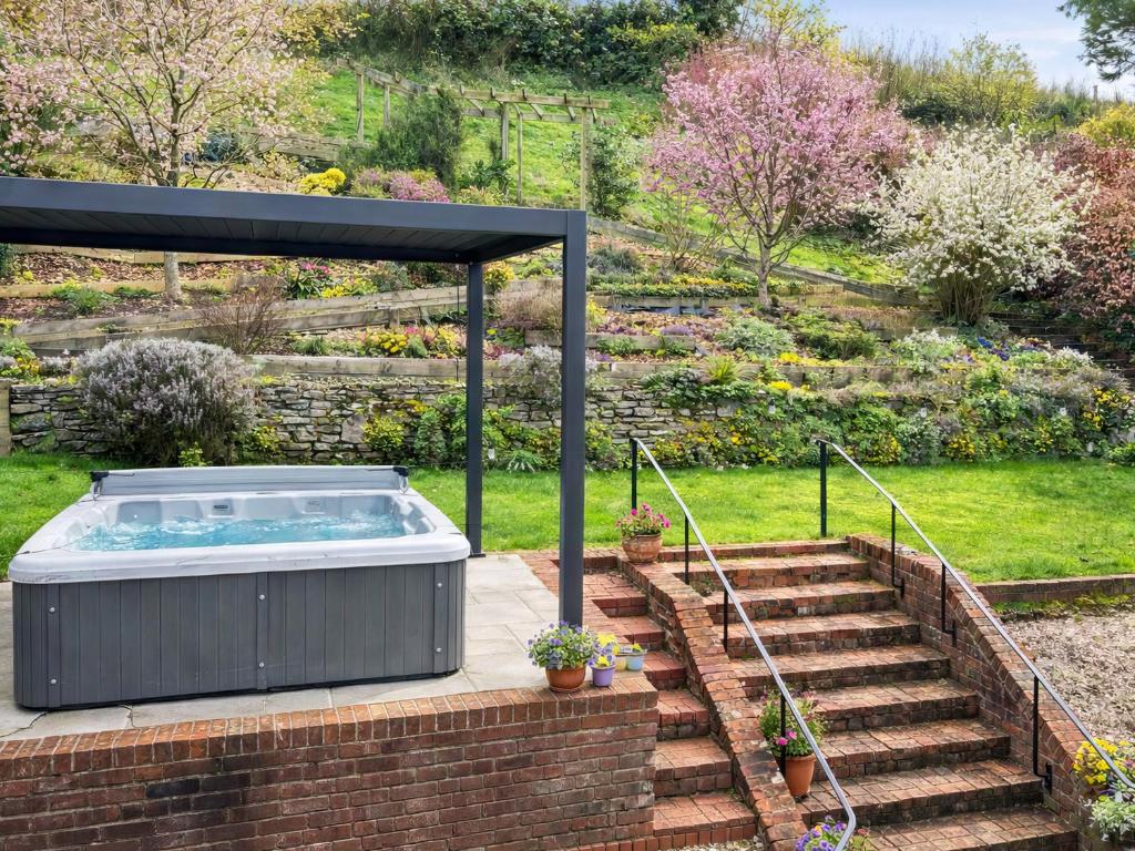 a hot tub in a garden next to some stairs at Blackthorn House in Blandford Forum