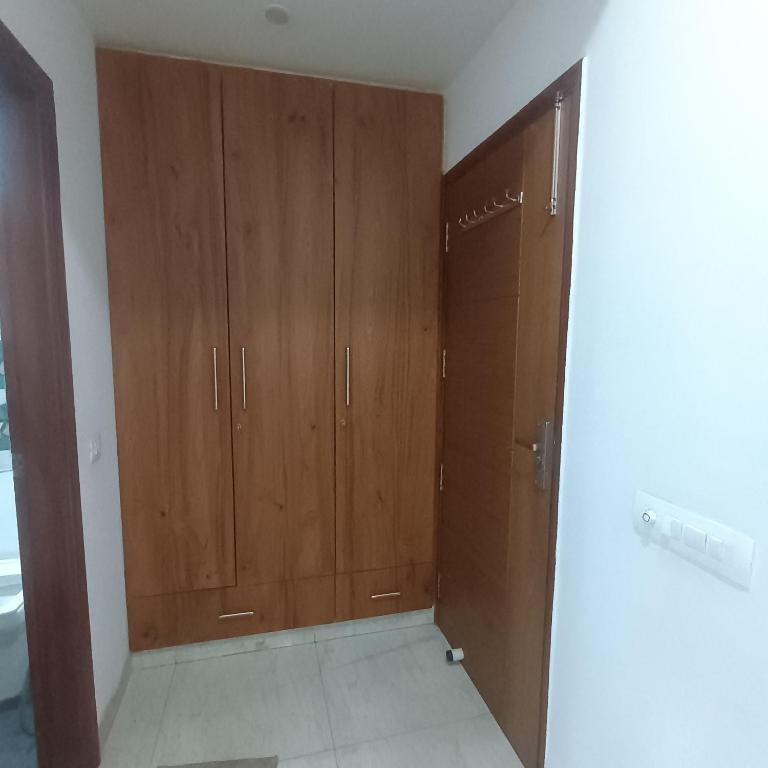 a room with two wooden cabinets in a room at Palam residency pg in Gurgaon