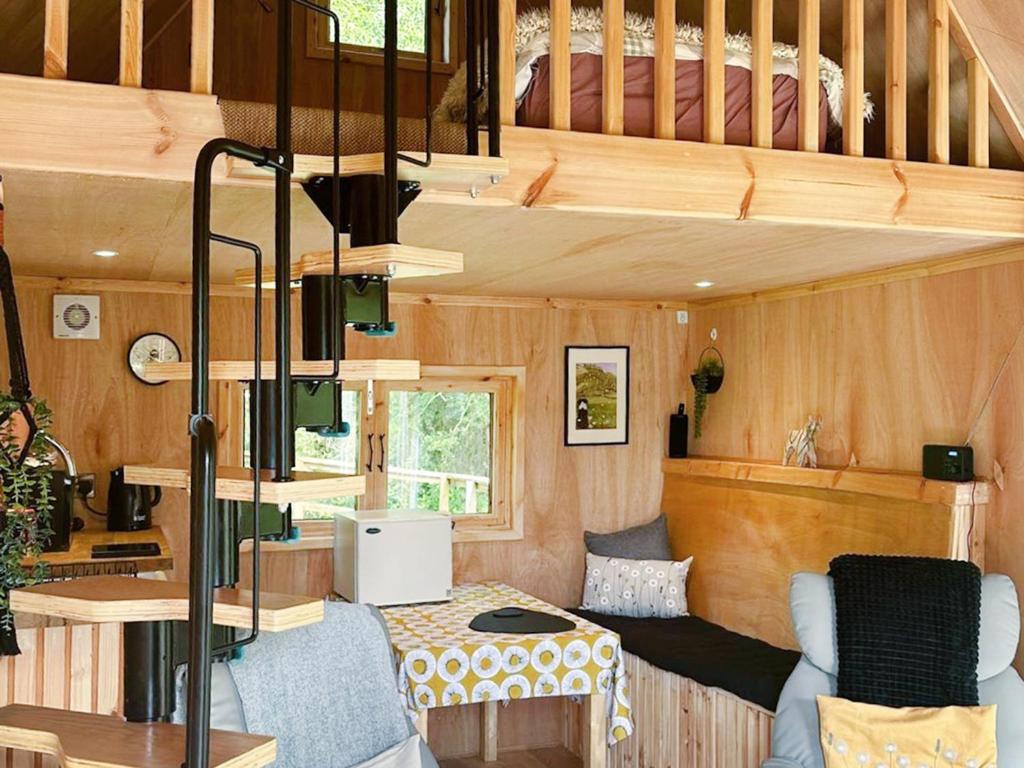 a tiny house with a staircase and a living room at Otter Gulley in Eddleston