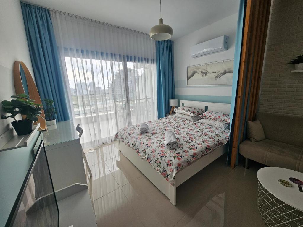 a small bedroom with a bed and a window at Caesar Resort Lux Studio Apt in Trikomo