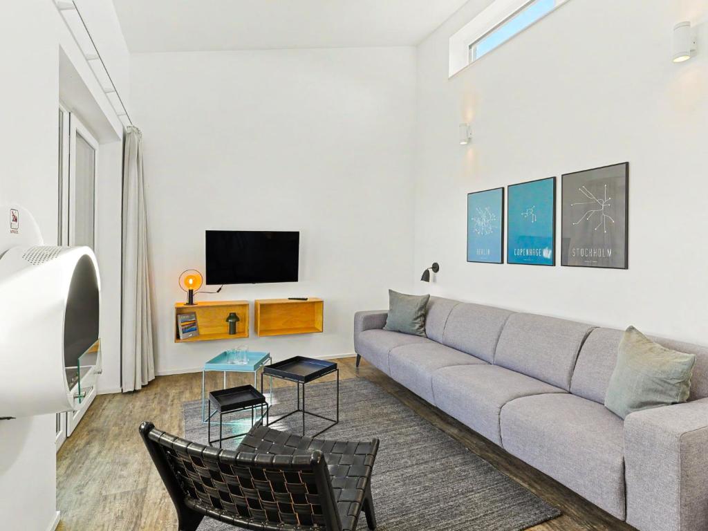 a living room with a couch and a tv at Holiday Home Haus Schmidt - 305 by Interhome in Lembruch