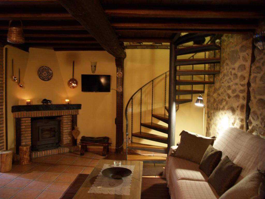 salon z kanapą i kominkiem w obiekcie La casa del Vado w mieście Hervás