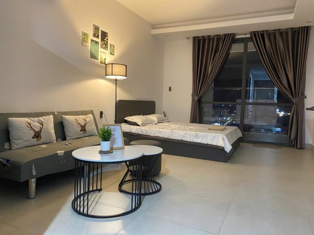 a living room with a bed and a table at SOHA House in Rạch Giá