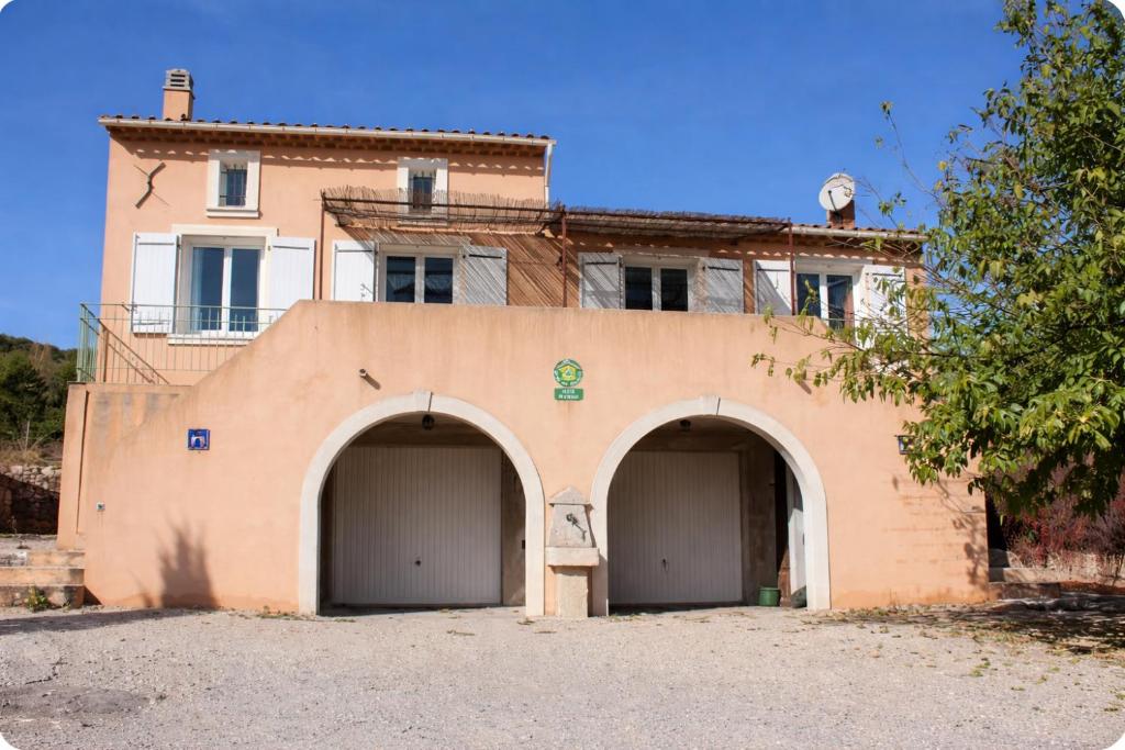 a building with two garage doors in front of it at Gîte Le Verdon in Quinson