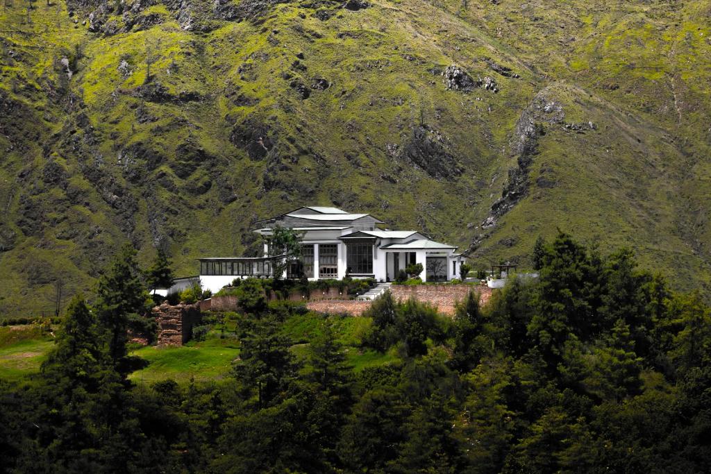 a house on a hill in front of a mountain at The Postcard Dewa, Thimphu, Bhutan in Thimphu