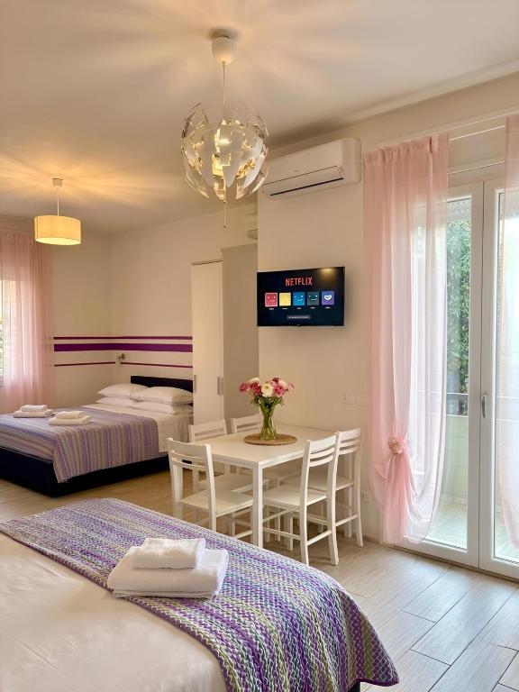 a bedroom with two beds and a table with chairs at The Sea Pearl Suite in Punta Marina