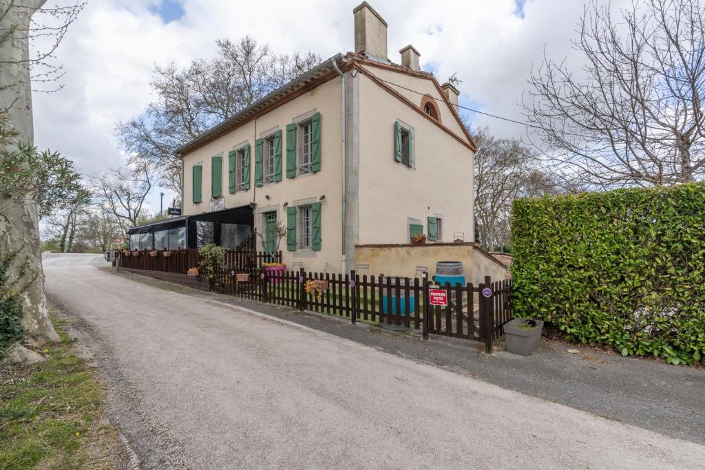 a house with a fence in front of a road at L'Estanquet - Maison d'Hôtes in Gardouch