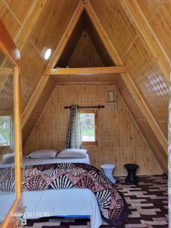 a bedroom with a bed in a wooden attic at EcoGlampLife in Kalgha