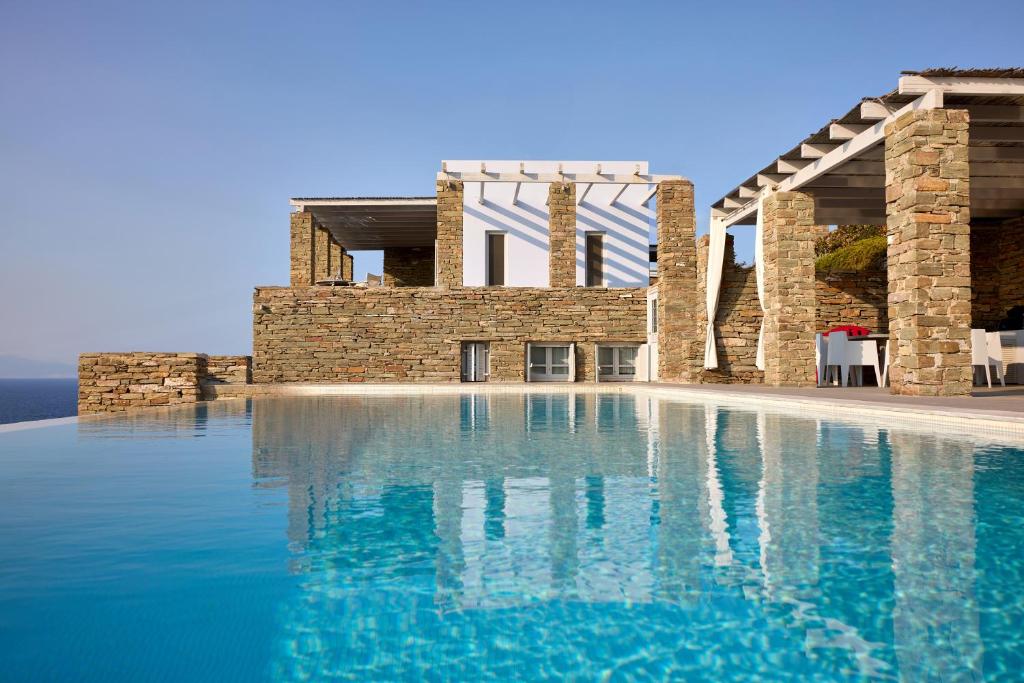 a large swimming pool in front of a building at Villa Litharia, enchanting location and view in Ioulis