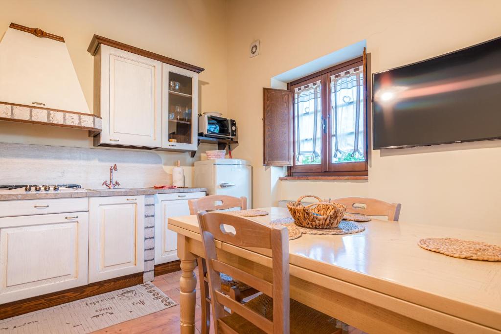 a kitchen with white cabinets and a table with chairs at PanElios Borgo Vacanze in Città della Pieve