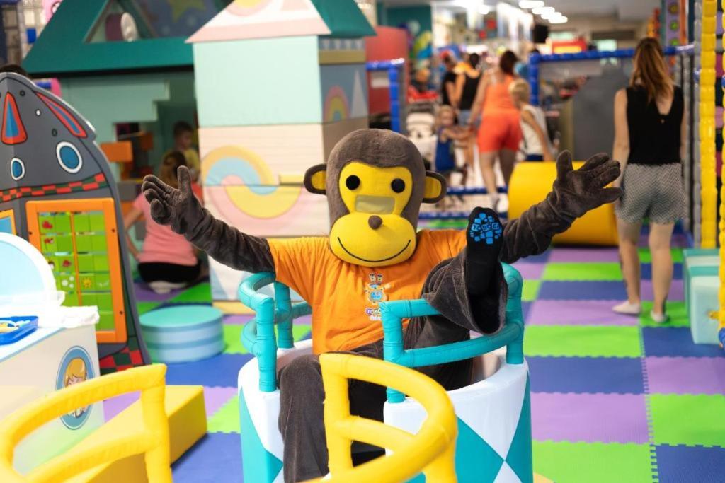 a stuffed monkey sitting in a chair in a toy store at Hotel Galaxie in Zlín
