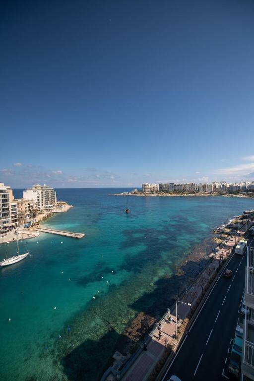 a view of the ocean with buildings and a city at Bayview Seafront 5A in St. Julianʼs