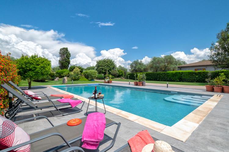 a swimming pool with a bunch of chairs around it at Villa Lavinia in Alghero