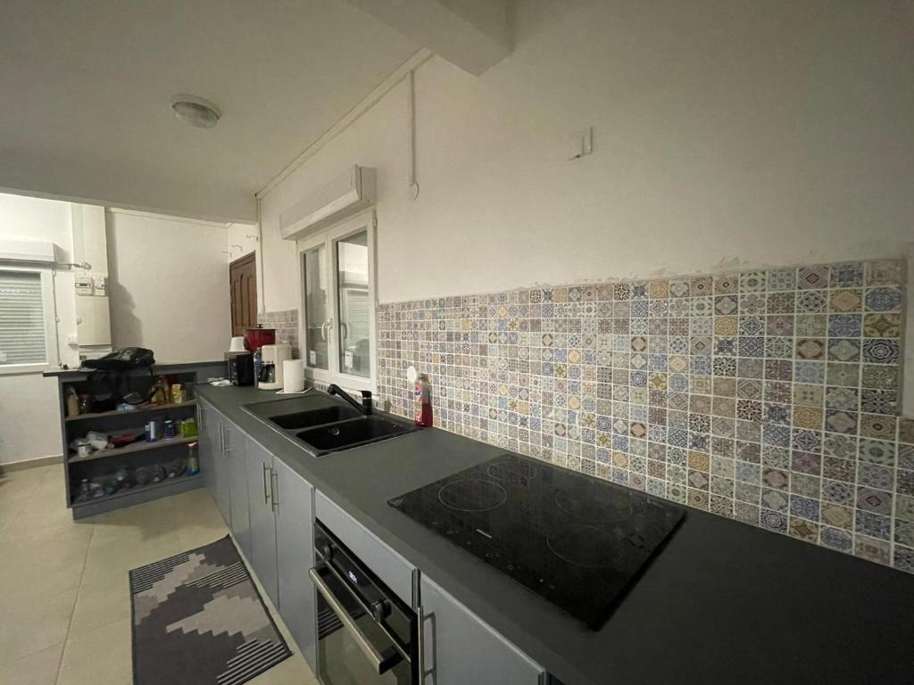 a kitchen with a sink and tiles on the wall at NOMADIA MOUSSa in Pamandzi