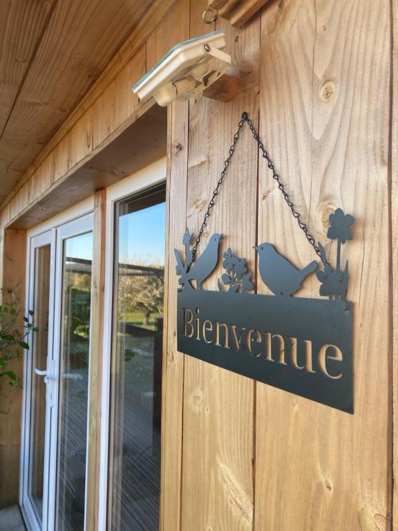 a sign hanging on the side of a building at Le colibri des prés in Maurens