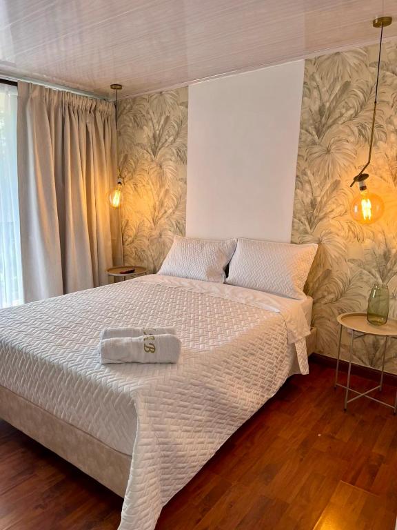 a bedroom with a large bed with a white blanket at Hotel Alamos del Bosque in Pereira