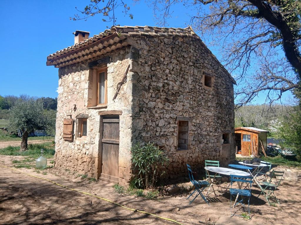an old stone house with a table and chairs at Les Bergeries d Orkan in Châteauneuf-du-Rhône