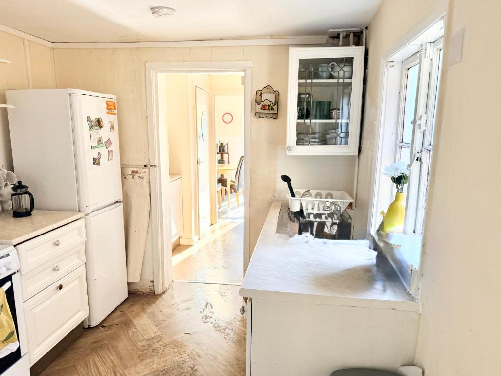 a kitchen with a white refrigerator and a table at Central Reading Cozy Spacious Room in Reading