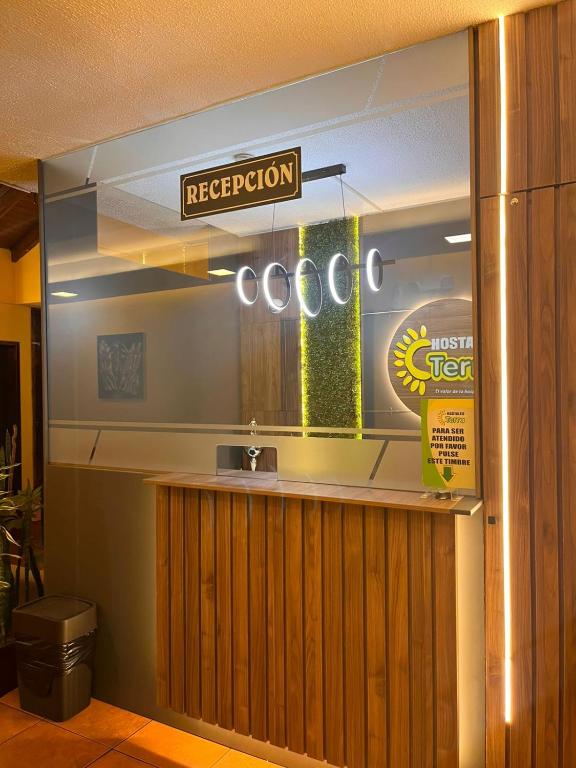 a restaurant counter with a sign that reads reception at Hostal Terra 3 - BASE AÉREA in Quito