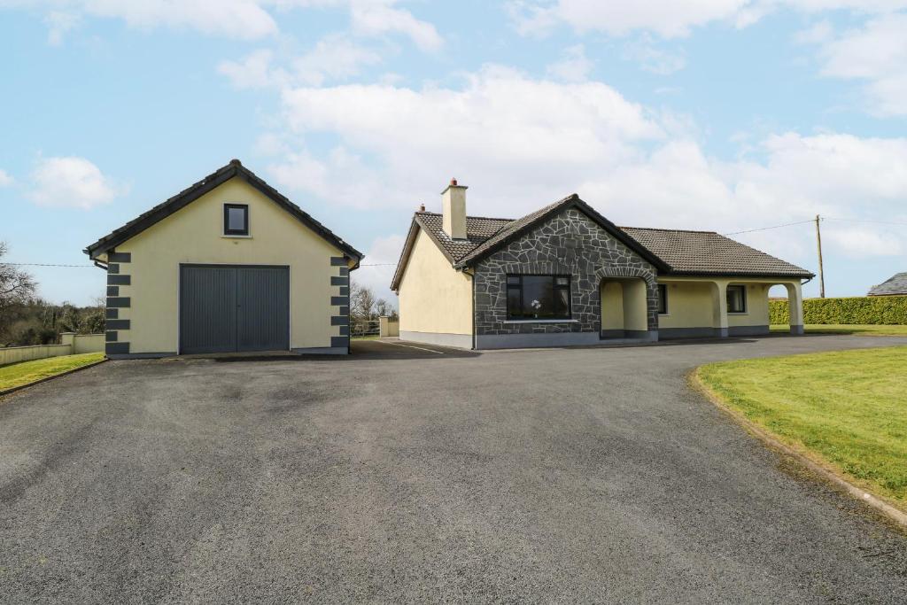 a detached house with a garage on a driveway at Castle View in Oughterard