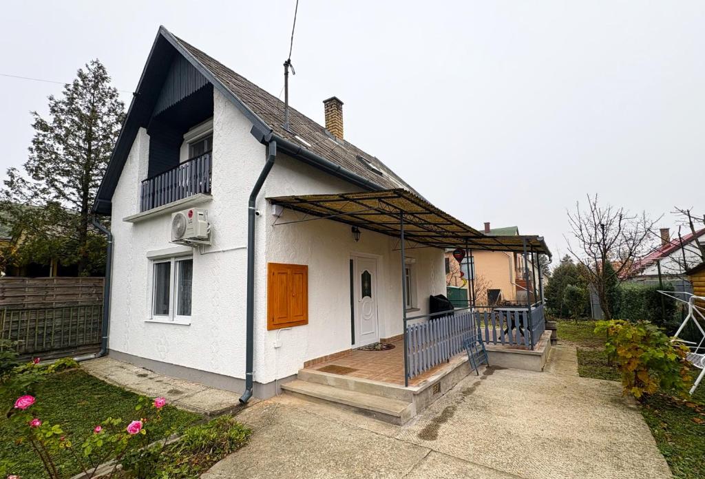 a white house with a porch and a balcony at Erika Vendégház in Igal
