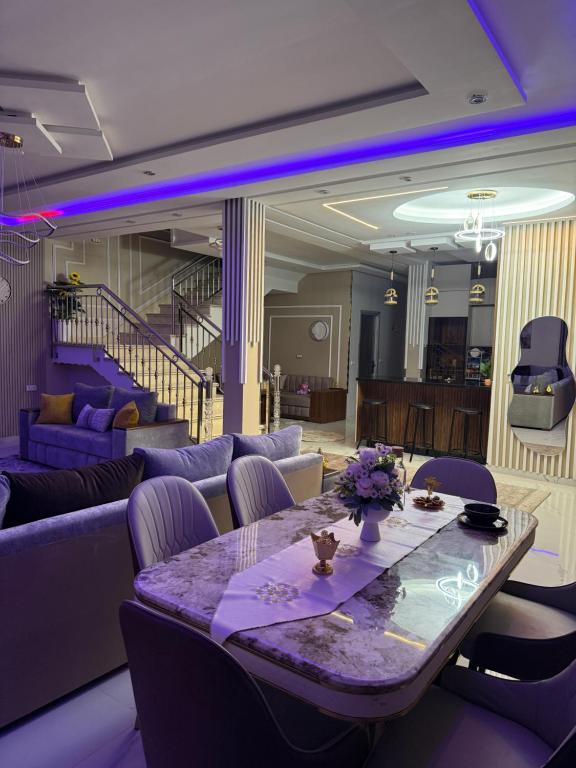 a living room with a table and purple furniture at Comfort House in Azib Aïn el Alak