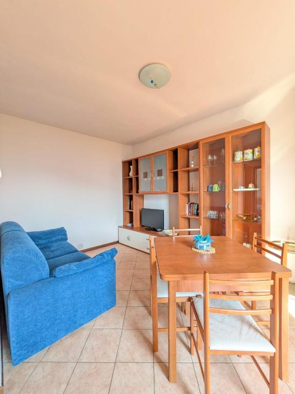 a living room with a blue couch and a table at Bosco Di Lago in Solto Collina
