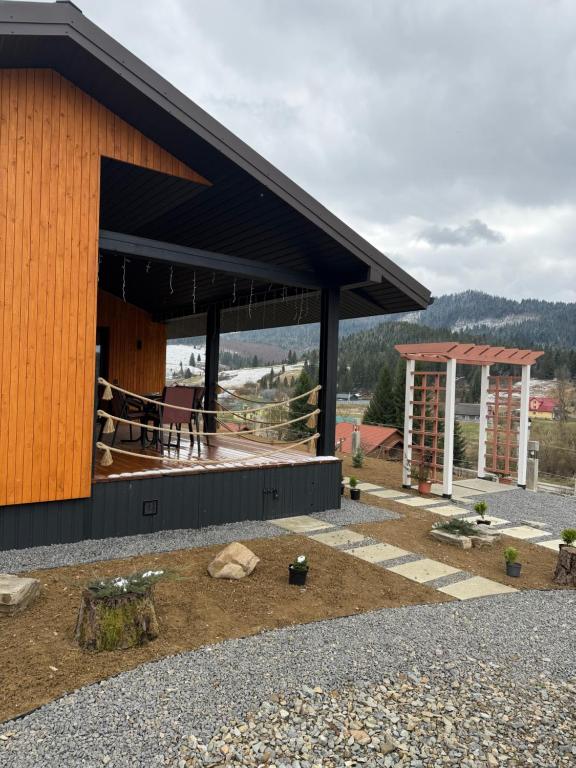 a building with a black roof with a view of a mountain at Sky hugs cottage in Volosyanka