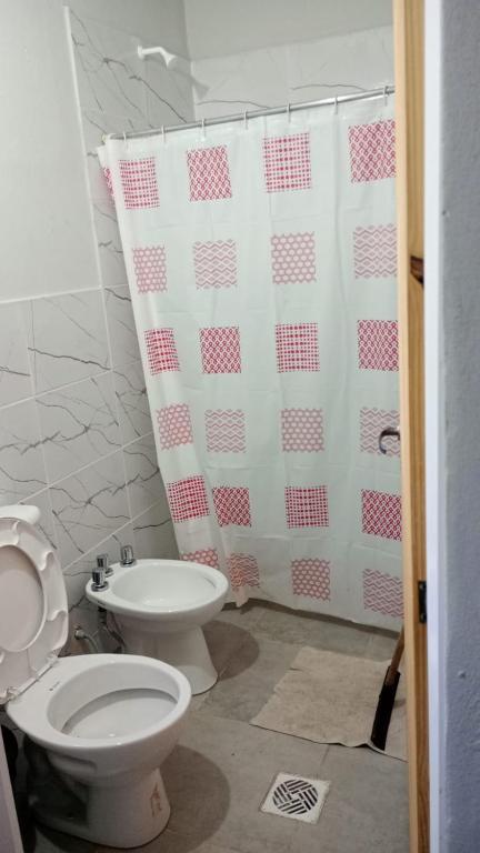 a bathroom with a toilet and a shower curtain at Posada el circulo in Chamical