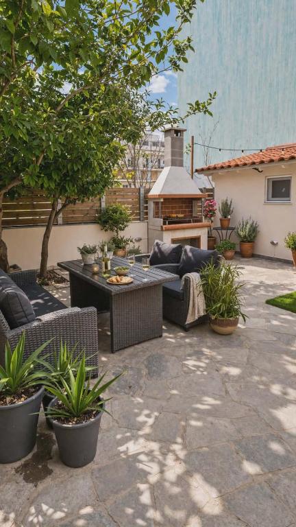 a patio with couches and a table and a grill at Secret Garden Volos in Volos