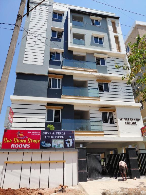 a building with a sign in front of it at sea shore stays in Rushikonda