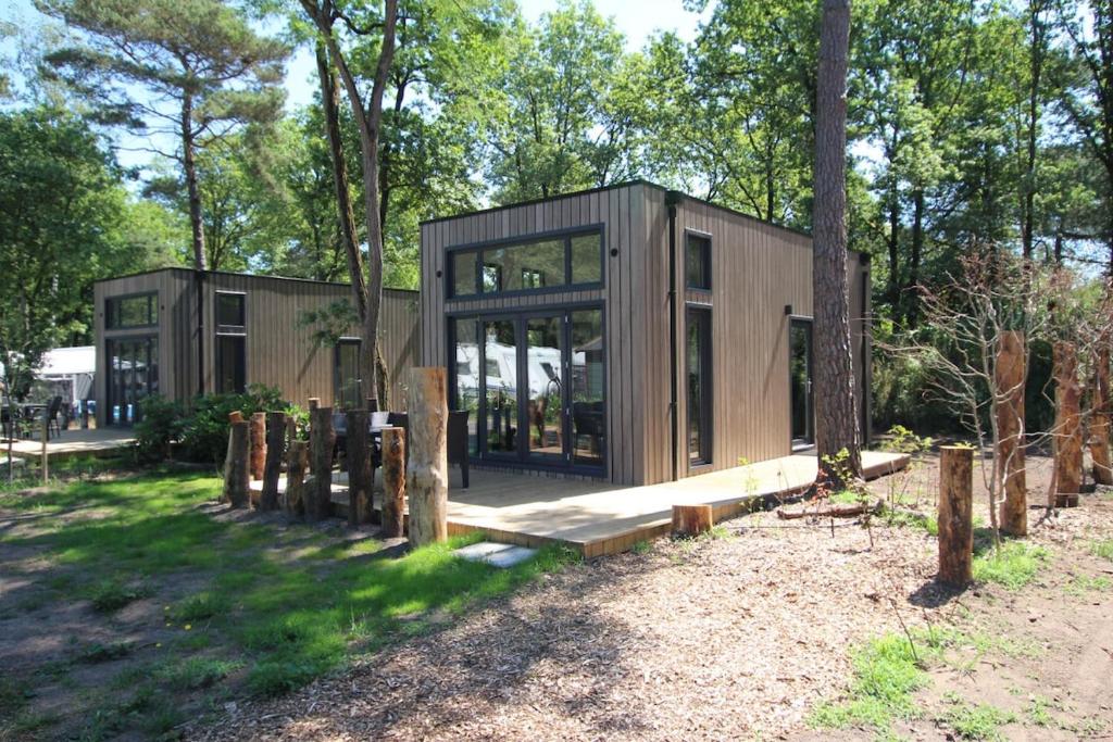 a tiny house in the woods with windows at Knusse Tiny House in de natuur in Baarle-Nassau