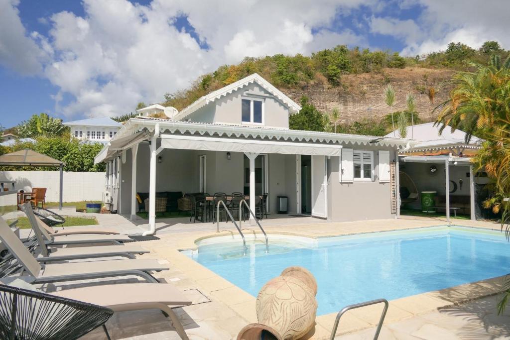a villa with a swimming pool and lounge chairs at Villa Diams Diamond in Le Diamant