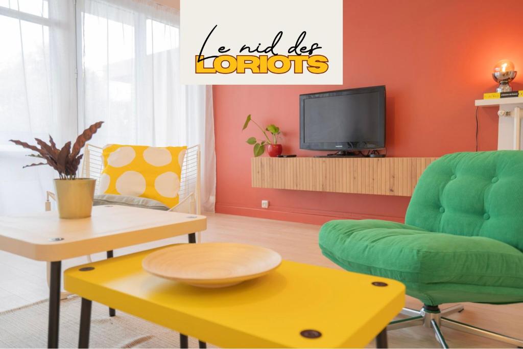 a living room with a couch and a table and a tv at Nid des Loriots - 3 Ch - Parking - Belle Beille Université in Angers