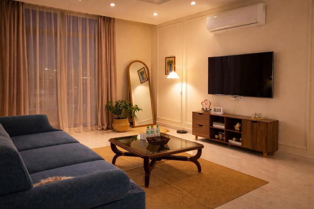 a living room with a blue couch and a tv at Homemie in Binh Hai