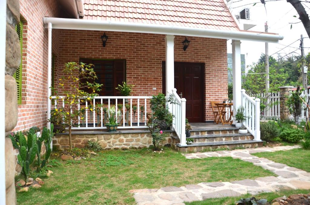 a brick house with a porch with a white railing at Kết nối home in Hai Phong