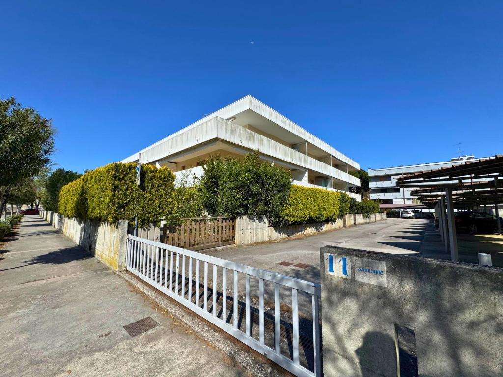 a building with a fence in front of a street at Condominio Piscina in Grado