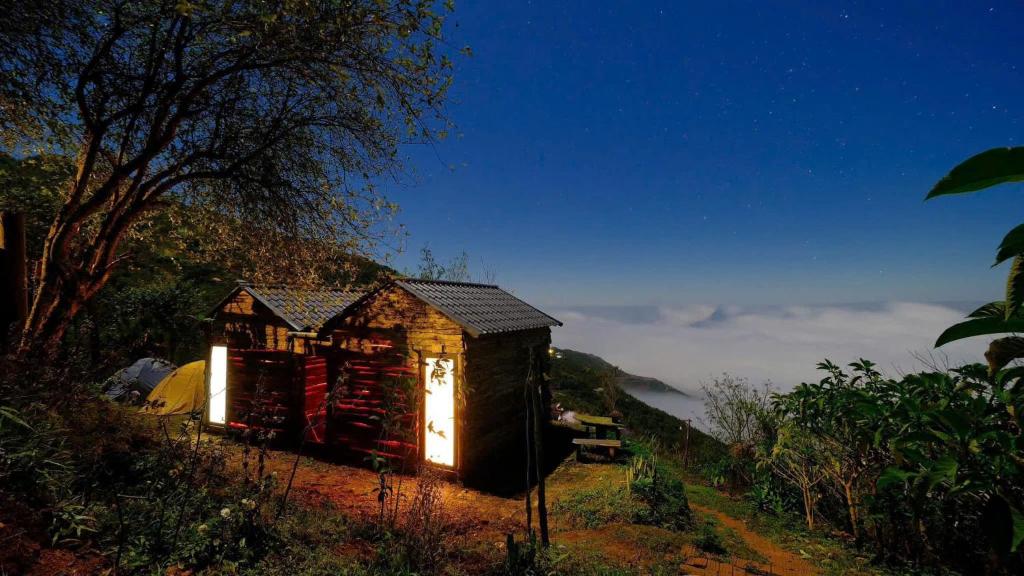a small shack on a hill with the lights on at Sơn Tra Our House in Bản Bé