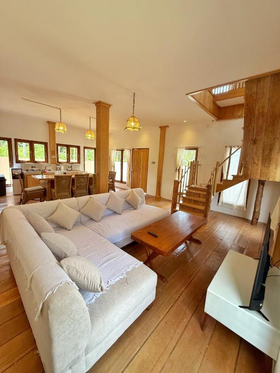 a living room with a large white couch and a table at Peach's House in Katiet