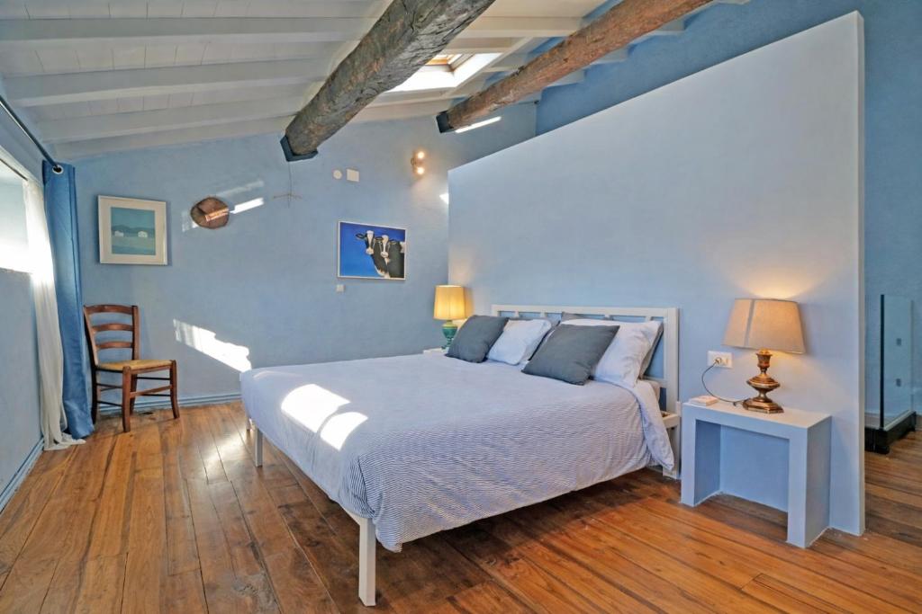 a bedroom with a bed and a blue wall at La Casa del Voltone in Pontremoli