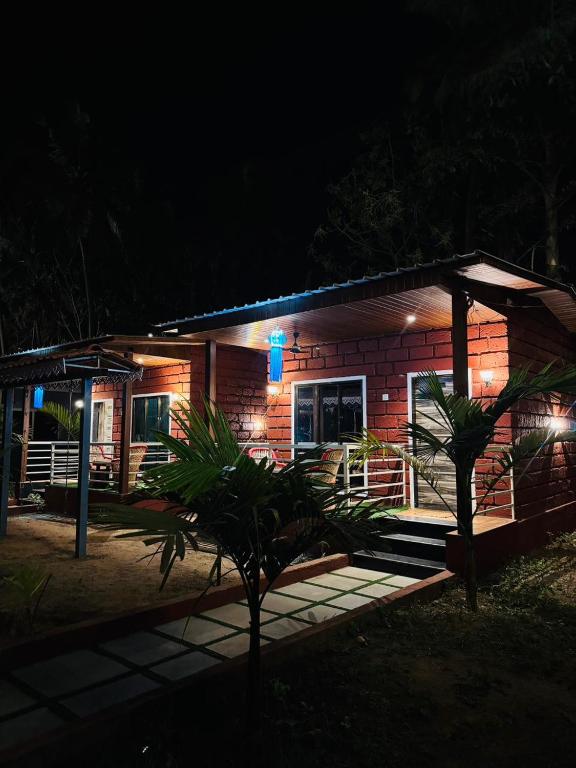 a small house with a blue sign on it at night at Coastal Home in Diveagar