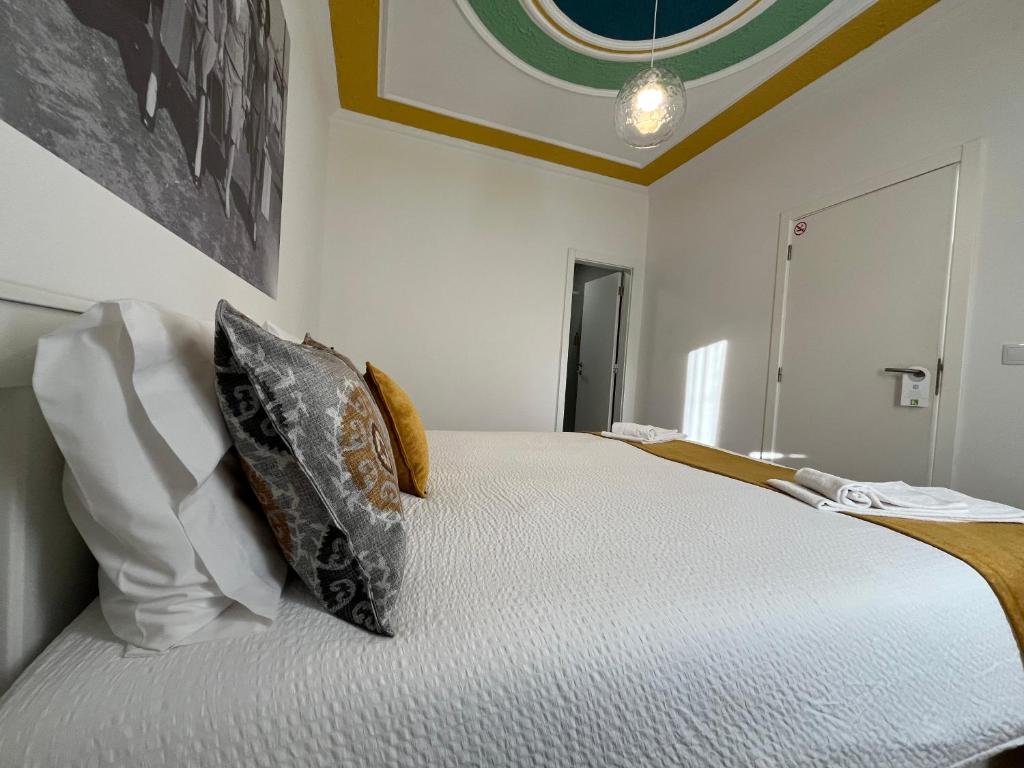 a bedroom with a large bed with two pillows at Casa do Ti Luís in Leiria