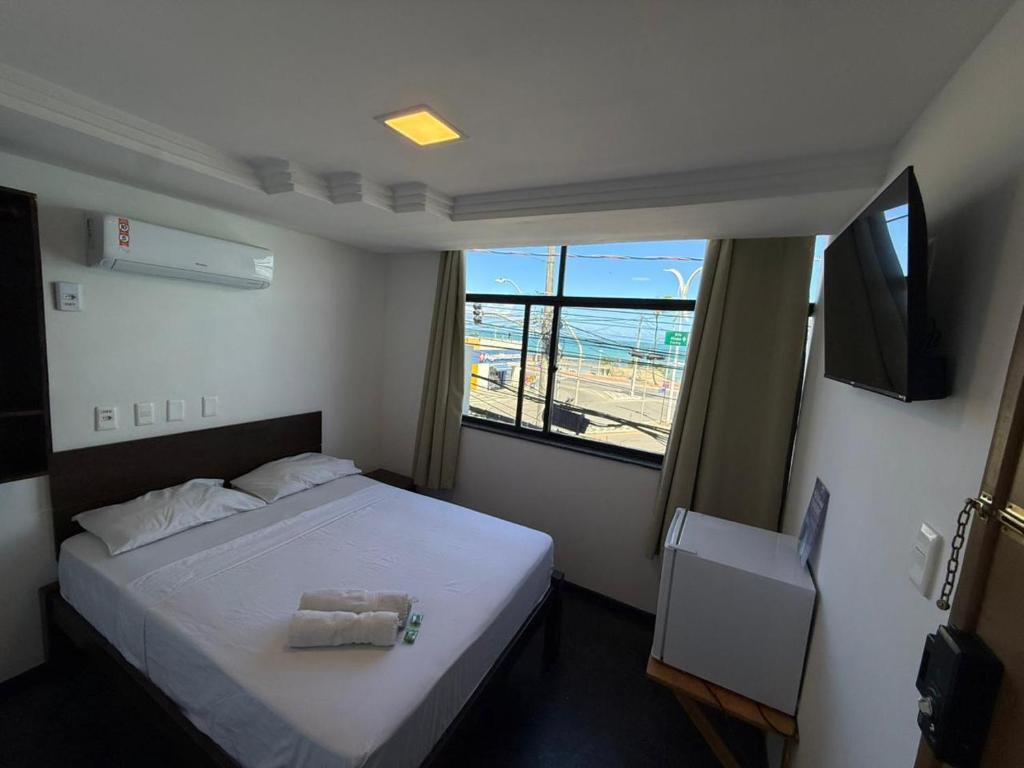 a bedroom with a white bed and a window at Hotel Bela Vista in Salvador