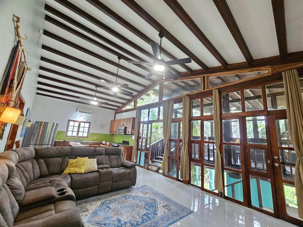 a living room with a couch and large windows at Vacation Home in Pedasí Town