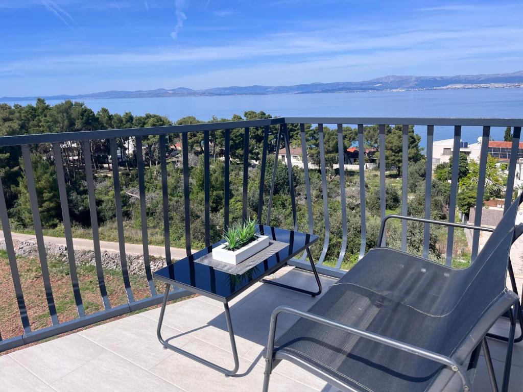a chair and a table on a balcony with a view of the water at Apartman Dani - Sutivan in Sutivan