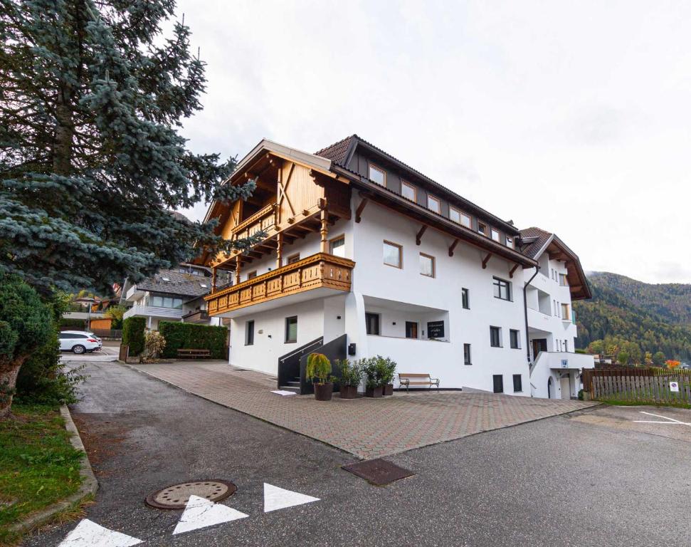 a white building with a balcony on top of it at Pension Hofer in Brunico