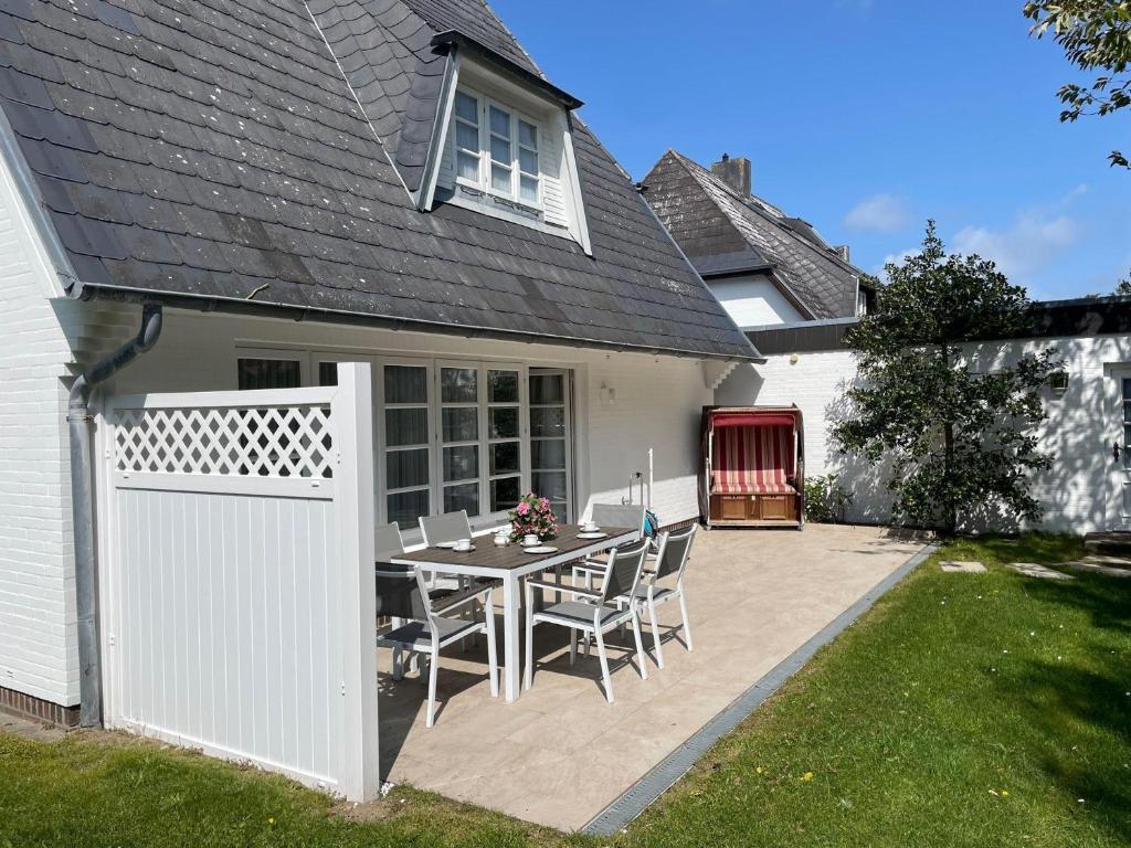 a patio with a table and chairs in front of a house at Haus-Neumann in Westerland