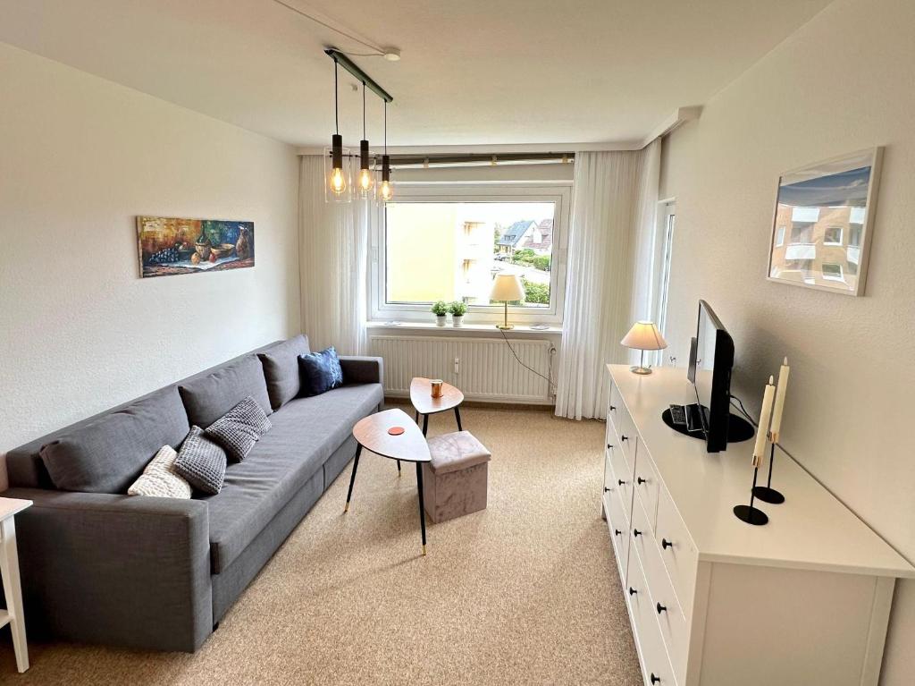 a living room with a gray couch and a tv at Ferienwohnung-20-A139 in Westerland